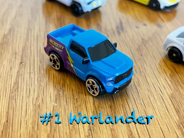 A carousel photo displaying the first vehicle named 'Warlander' out of an array of 'Standard cars', at full size. The car/truck is painted light-blue with a electricity sign printed.