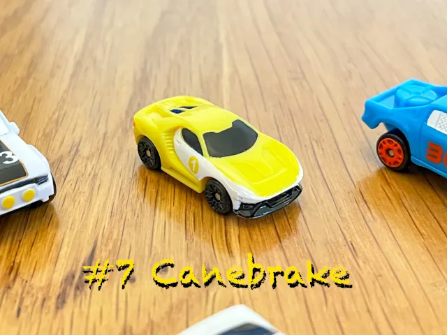 A carousel photo displaying the seventh vehicle named 'Canebrake' out of an array of 'Standard cars', at full size. The car is painted banana-yellow with a white-side strips printed.