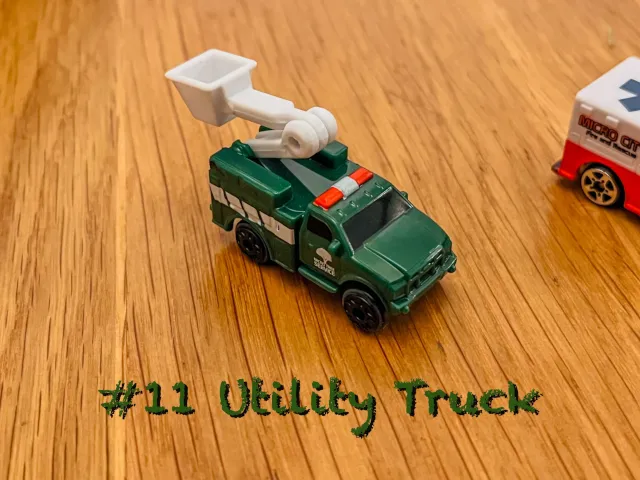 A carousel photo displaying the eleventh vehicle named 'Utility Truck' out of an array of 'Large Vehicles', at full size. The truck is painted forest-green with a white company title 'Micro Tree Service' and tree symbol printed on the right side door.