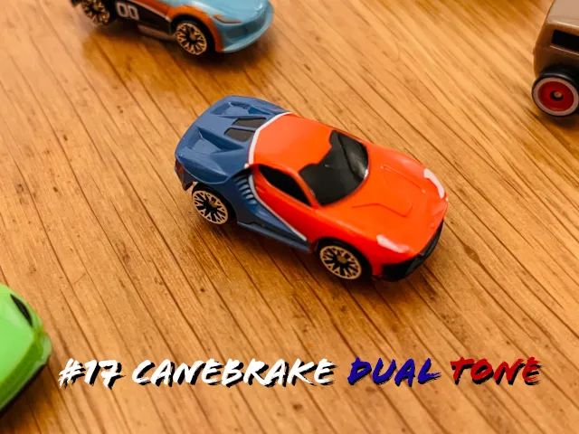 A carousel photo displaying the seventeenth vehicle named 'Canebrake Dual Tone' out of an array of 'Deluxe Cars', at full size. The car is painted red-orange with a dark-blue backdrop trunk.