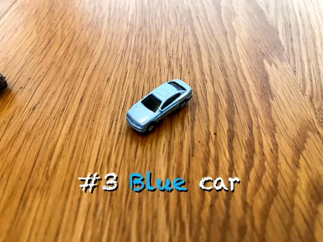 A carousel photo displaying the third car named 'Blue car' out of an array of V.I.A. 'mini Standard cars', at mini size. The car is painted light-blue with a standard SUV design.