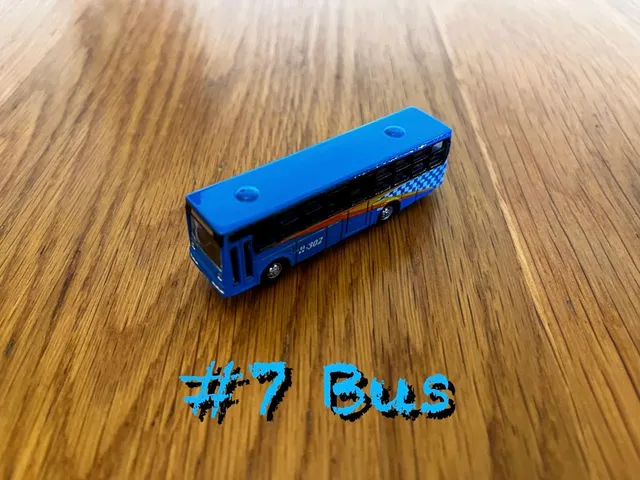 A carousel photo displaying the seventh vehicle named 'Bus' out of an array of V.I.A. 'mini Large Vehicles', at mini size. The vehicle is painted Dodgerblue with a standard coach design.