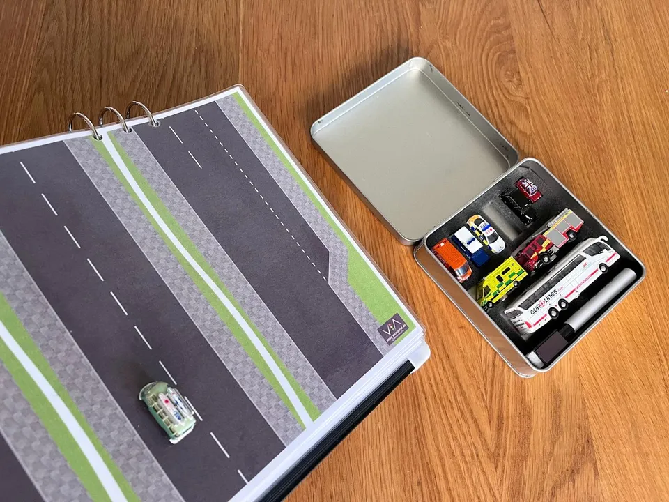 A zoomed out photo showcasing a green magnetic bus positioned on one of the road layout's lanes. Demonstrating the magnetic capabilities like staying on the layout for example.