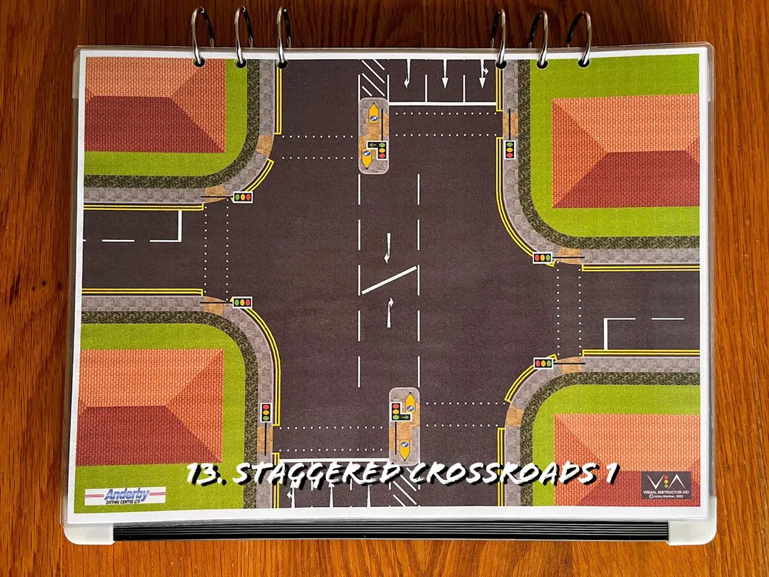 A carousel photo displaying the thirteen plan named 'staggered crossroads 1' out of an array of roads layouts, at full size. Consisting of multiple lanes and double hatching lanes separated in the middle.
